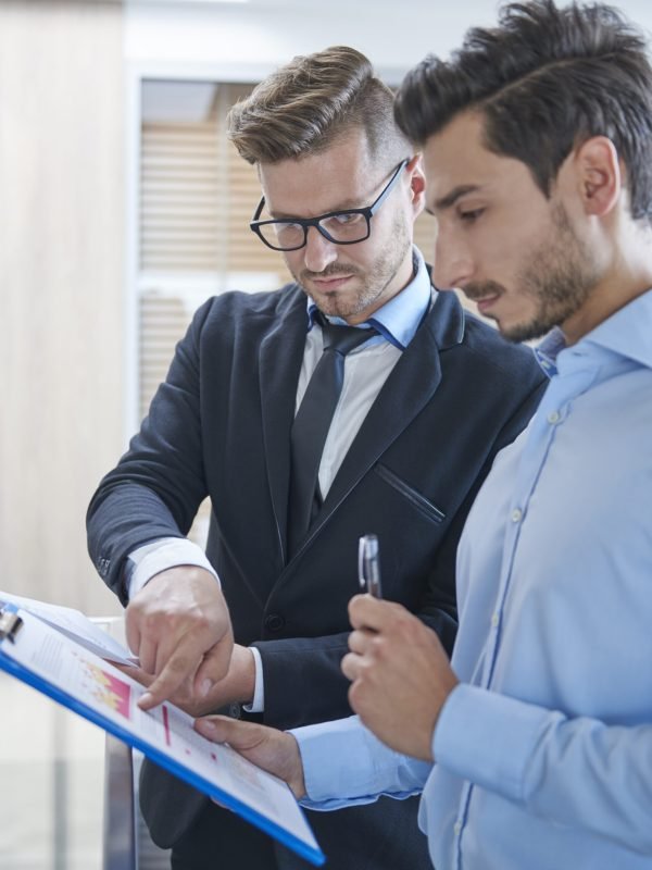 Two men analyzing some documents